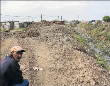  ?? Picture: JUDY DE VEGA ?? RUBBISH MOUNTAIN: Resident Leon Lewis checks on the work the metro has been doing unblocking the drainage lines in the Mackay’s Ground-Greenfield­s area of Missionval­e