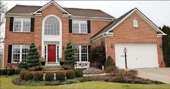  ??  ?? ABOVE: The brick-andframe home has about 4,500 sq. ft. of living space. The house sits on a halfacre lot with a pergola that covers part of the deck. The 4-bedroom home includes a finished basement.