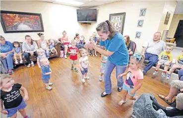  ?? [PHOTOS BY STEVE GOOCH, THE OKLAHOMAN] ?? Shelby Farnsworth leads children in a “Rhythm and Rhyme” dance at the Yukon Community Center.