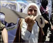  ?? IBRAHEEM ABU MUSTAFA/REUTERS ?? A Palestinia­n man holds a symbolic key during a rally after Nakba Day in Rafah in the southern Gaza Strip.