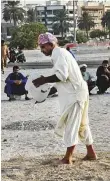  ??  ?? Mohammad Iqbal waters the sand pit before a fight. Workers turned wrestlers train throughout the week after their duty hours for this one day of excitement.