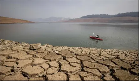  ?? ETHAN SWOPE — THE ASSOCIATED PRESS FILE ?? A kayaker fishes in Lake Oroville in Oroville as water levels remain low.