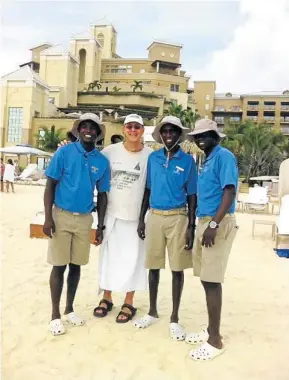  ??  ?? MADE IT: The writer at his hotel on Grand Cayman with some hotel staff, all from Kenya