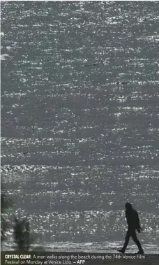  ?? — AFP ?? A man walks along the beach during the 74th Venice Film Festival on Monday at Venice Lido.