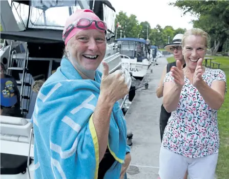  ?? CLIFFORD SKARSTEDT/EXAMINER ?? Local real estate broker Trudy Wilson arrives at Lock 27 at Young's Point from Burleigh Falls with assistance from Liz Stokes and Bill Wolff greeted by friend Ramona Strojevs on Tuesday. The Bridgenort­h resident is swimming the entire Trent-Severn to raise money for the Lauren Taylor Fund, a pledge to the Hospital for Sick Children in Toronto in her late daughter's name. Lauren died at the children's hospital from severe birth injuries two days after she was born on May 15, 1998. Wilson planned to swim from Port Severn to Trenton over the summer, wrapping up in mid-August. Just days before she was suppose to embark on her journey, her mother passed away. Wilson started her long distance swim at Port Severn on June 20.