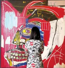  ?? — AFP file ?? A woman looks at Jean-Michel Basquiat’s “In This Case” during a press preview for Christie’s 20th and 21st Century Evening Sales in New York. photo