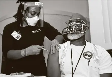  ?? Yi-Chin Lee / Staff photograph­er ?? Stephen Fowler, with the Houston SolidWaste Management Department, gets his first dose of Moderna vaccine Monday at City Hall. Metro, meanwhile, still is in planning stages of sticking bus drivers.