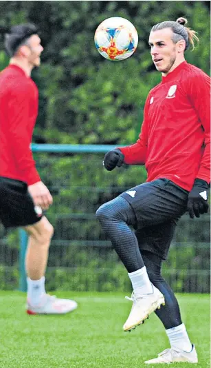  ??  ?? Talisman: Gareth Bale prepares to face Slovakia tonight; (below) Ryan Giggs wants to lighten his star man’s burden