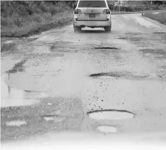  ??  ?? A vehicle moves along a pothole-riddled and muddy stretch between Tatau and Selangau.