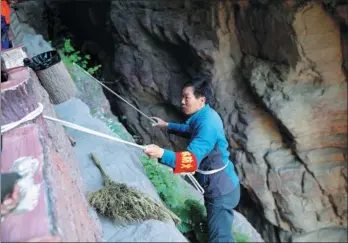  ?? PHOTOS PROVIDED TO CHINA DAILY ?? Guo Youshun collects litter from a cliff at the Yuntai Mountain scenic spot in Jiaozuo, Henan province.