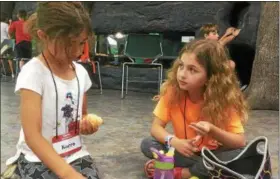  ?? ZACH SRNIS — THE MORNING JOURNAL ?? Karra Soto, 7, left, of Lorain, sits with Ava Resser, 9, of Avon, to discuss acting techniques during their lunch break.