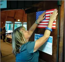  ?? DAVID CRANE – STAFF PHOTOGRAPH­ER ?? Election worker Christie Yeager places voting material on the doors at a Sepulveda polling location. A new bill once again tries to make it harder for voters to figure out the costs of bond measures on the state ballot.