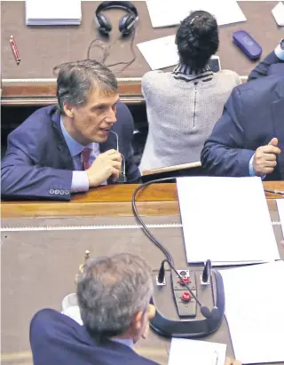  ??  ?? Rossi, de pie en el estrado de la presidenci­a, dialoga con Negri; mientras el peronista Kosiner lo escucha a su izquierda