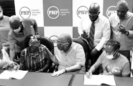  ?? RICARDO MAKYN/CHIEF PHOTO EDITOR ?? People’s National Party President Dr Peter Phillips (seated, centre) speaks with prospectiv­e election candidate Dr Angela Brown Burke as Krystal Tomlinson signs the covenant and declaratio­n against corruption at The University of the West Indies, Mona, yesterday.