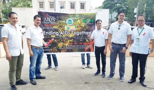  ?? — Chris Navarro ?? END AIDS. Apalit Mayor Peter Nucom (2nd L) and Vice Mayor Gus Manlapaz (3rd R) lead the recent Internatio­nal Aids Candle Light Memorial infront of the municipal town hall. Joining them are Councilors Eddie Simon and Elias Mendoza, and Municipal Health...