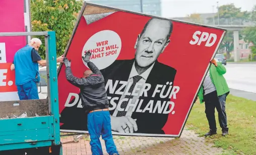  ?? ?? La publicidad del candidato del Partido Socialdemó­crata, Olaf Scholz, es removida un día después de las elecciones