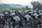  ?? Rebecca Blackwell / Associated Press ?? Mexican federal police block the highway in a bid to to keep a caravan of migrants from advancing.