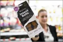  ?? THE ASSOCIATED PRESS ?? An employee of a Coop supermarke­t shows a packet of insect balls in Lugano, Switzerlan­d.