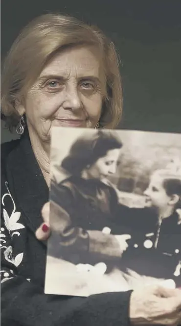  ??  ?? 0 Tova Friedman, an 82-year-old Holocaust survivor holds a photo of herself as a child with her mother