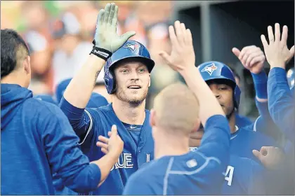  ?? AP PHOTO ?? The Toronto Blue Jays’ Michael Saunders is congratula­ted by teammates in the dugout after hitting a three-run homer during an American League matchup against the Orioles Friday in Baltimore. Saunders, who is from Victoria, B.C., but who has...