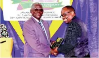  ?? PHOTOS BY CARL GILCHRIST ?? Fabian Smith (right) collects his plaque from Radcliffe Walters, chairman, St Ann Parish Library network.