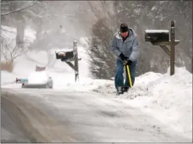  ?? GENE WALSH — DIGITAL FIRST MEDIA ?? A man clears his driveway of snow on Colonial Avenue in Collegevil­le on Thursday.