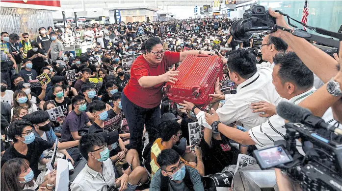 ?? PHILIP FONG/AFP ?? Manifestan­tes y pasajeros se mezclaron ayer en el tumulto de la toma del aeropuerto de Hong Kong