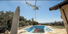  ??  ?? A helicopter with a monsoon bucket picks up water from a Redwood Valley property.