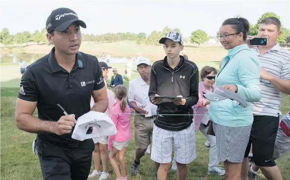  ?? — THE CANADIAN PRESS ?? Jason Day signs autographs during the Canadian Open pro-am Wednesday at Glen Abbey Golf Club in Oakville, Ont.