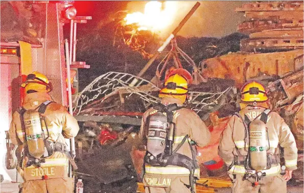  ?? GREG NIKKEL/WEYBURN REVIEW ?? Firefighte­rs monitor a pile of scrap wire burning in the yard of Mryglod Steel and Metals in Weyburn Wednesday.