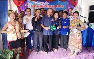  ??  ?? Penguang cuts the ribbon to officiate at the function. From second right are Alexander, village headman Paberi Magelit and Penguang’s wife Datin Monica Ukong.