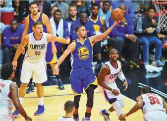  ?? Frederic J. Brown / AFP / Getty Images ?? The Clippers tried to surround Warriors point guard Stephen Curry on Thursday, but he still soared to the forefront in Golden State’s win in Los Angeles.