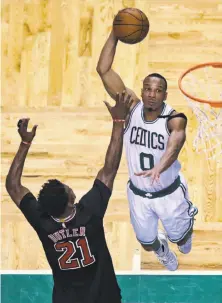  ?? Charles Krupa / Associated Press ?? Celtics guard Avery Bradley dunks over Bulls forward Jimmy Butler for two of his 24 points, in addition to superb defense.
