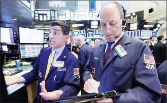  ??  ?? Specialist Peter Mazza (left), and trader Gordon Charlop work on the floor of the New York Stock Exchange. (AP)