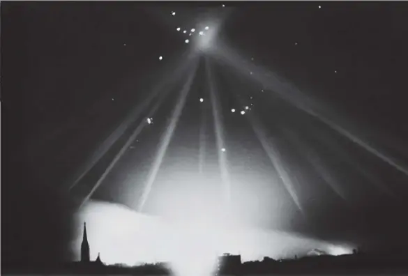  ?? ?? Below: A Bomber Command aircraft is “coned” by searchligh­ts. Flak, directed toward the bomber by anti-aircraft guns, can be seen exploding near where the searchligh­ts converge.
Far left: Enemy antiaircra­ft guns fire on Allied planes.
Left: A system known as FIDO (Fog, Intensive, Dispersal Of), consisting of a network of pipes and fuel burners, was installed at the sides of runways in Bomber Command airfields to clear away fog. Between 1943 and 1945, 2,500 aircraft landed safely in fog thanks to FIDO.
