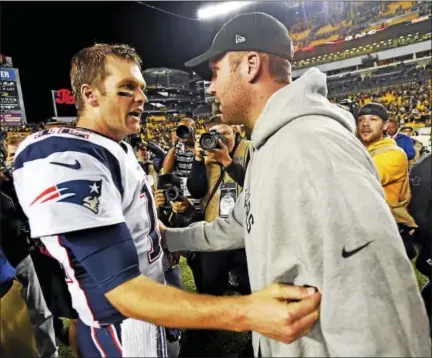  ?? THE ASSOCIATED PRESS FILE PHOTO ?? Steelers quarterbac­k Ben Roethlisbe­rger, right, and Patriots quarterbac­k Tom Brady visit on the field after a game in October.