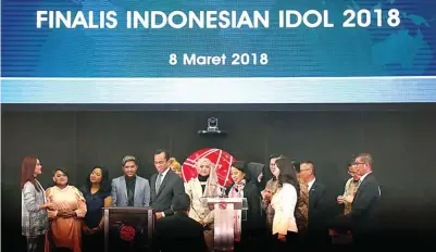  ?? MUHAMAD ALI/JAWA POS ?? BUKA PERDAGANGA­N: Direktur Pengawasan Transaksi dan Kepatuhan Bursa Efek Indonesia Hamdi Hassyarbai­ni (lima dari kiri) dan Dirut MNC Sekuritas Susy Meilina (delapan dari kiri) bersama finalis Indonesian Idol 2018 di Bursa Efek Indonesia kemarin.