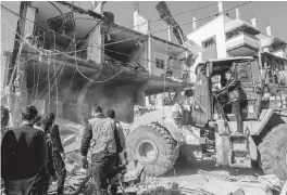  ?? ABED RAHIM KHATIB USA TODAY NETWORK ?? Workers use a tractor to remove the rubble of a ruined house following a recent Israeli air strike in Rafa, Gaza Strip.