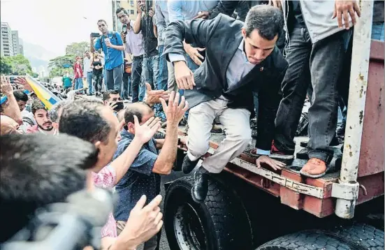  ?? FEDERICO PARRA / AFP ?? Dar el salto. Juan Guaidó, autoprocla­mado presidente, saltando ayer de un camión en su gira por los barrios de Caracas para explicar su política