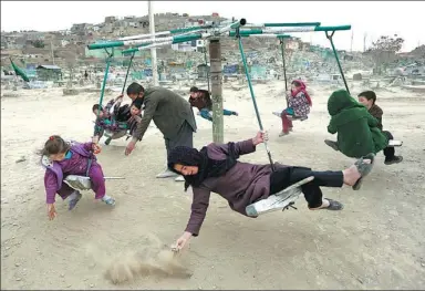  ?? RAHMAT GUL / ASSOCIATED PRESS ?? Children ride on swings in Kabul, Afghanista­n, last week.