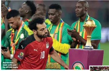  ?? ?? Heartbroke­n… Salah walks past the AFCON trophy