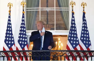 ?? WIN MCNAMEE/GETTY ?? Former US President Donald Trump removes his mask on his return to the White House from hospital on October 5, 2020. He spent three days hospitalis­ed for coronaviru­s