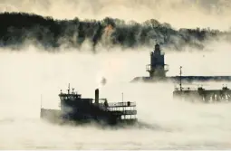  ?? ROBERT F. BUKATY/AP ?? Sea smoke rises Saturday from the Atlantic Ocean as a ferry passes Spring Point Ledge Light near South Portland, Maine. The temperatur­e was about minus 10.