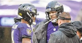  ?? KENNETH K. LAM/BALTIMORE SUN ?? Ravens starting quarterbac­k Lamar Jackson, left, talks on the sideline during a timeout in the second quarter as backup quarterbac­k Joe Flacco looks on.