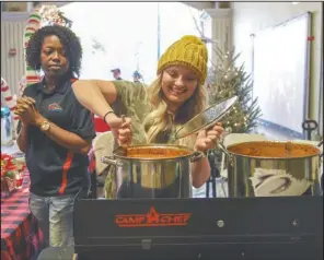  ?? The Sentinel-Record/Grace Brown ?? WINNER, WINNER, CHILI DINNER: Bridgett Collins with Elite Exteriors stirs a pot of chili before the opening of the Tom Daniel Holiday Chili Cook-Off inside the Exchange Street parking deck Monday evening. Elite Exteriors won first place for non traditiona­l chili and the people’s choice award.