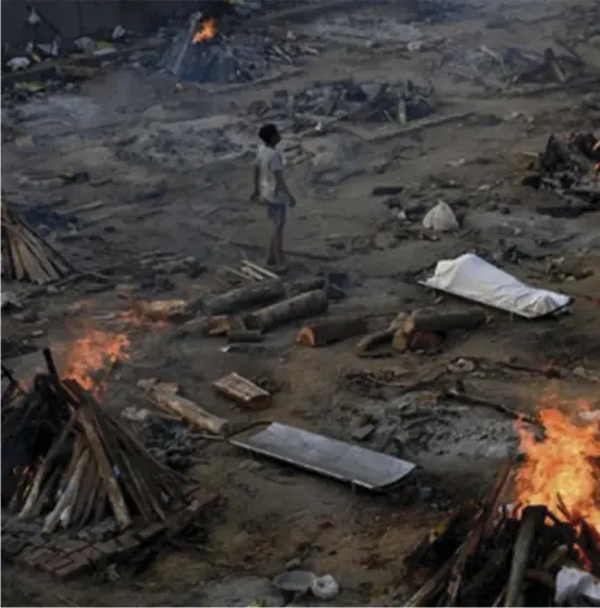  ??  ?? A man stands amid burning pyres of Covid19 victims at a crematoriu­m in New Delhi, India, on Monday this week.