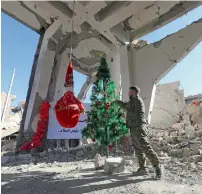  ?? — AFP ?? A man arranges a tree as part of Christmas celebratio­ns at the heavily-damaged Armenian Catholic Church of the Martyrs in the eastern Syrian city of Raqqa.