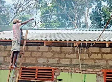  ?? ?? A man pours water on the roof of his house to cool the sheets