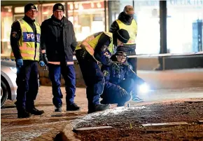  ?? AP ?? Police examine the scene after several people were attacked in Vetlanda, Sweden.