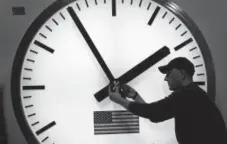  ?? Associated Press file ?? A worker adjusts hands on a stainless steel tower clock at Electric Time Company, Inc. in Medfield, Mass.